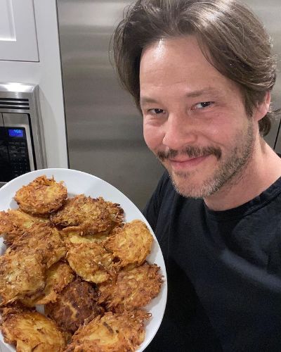 Picture of Ike Barinholtz with crispy potato fries on his hand which was made by himself.